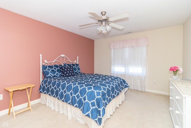 bedroom with visible vents, baseboards, light colored carpet, and a ceiling fan