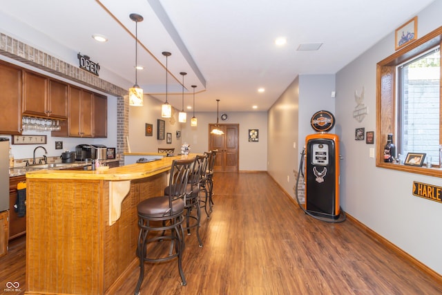 kitchen featuring a kitchen breakfast bar, a center island, butcher block counters, baseboards, and dark wood-style flooring