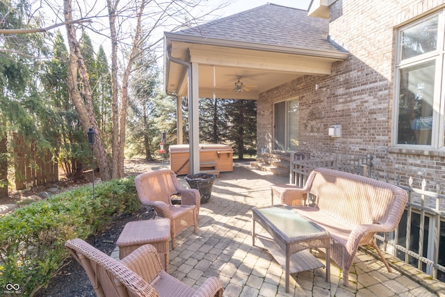 view of patio with ceiling fan, outdoor lounge area, and a hot tub