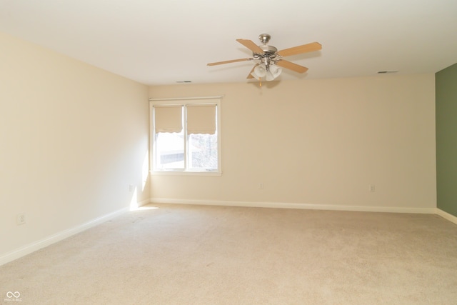 spare room with visible vents, baseboards, light carpet, and ceiling fan