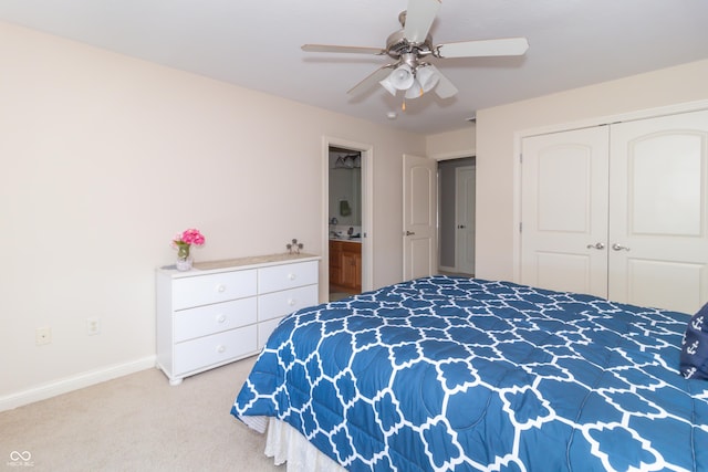 carpeted bedroom featuring a closet, baseboards, ceiling fan, and ensuite bathroom