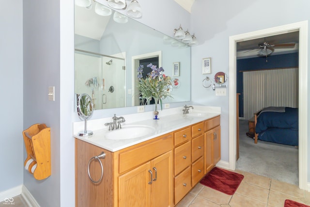 ensuite bathroom with double vanity, a sink, tile patterned flooring, a shower stall, and connected bathroom