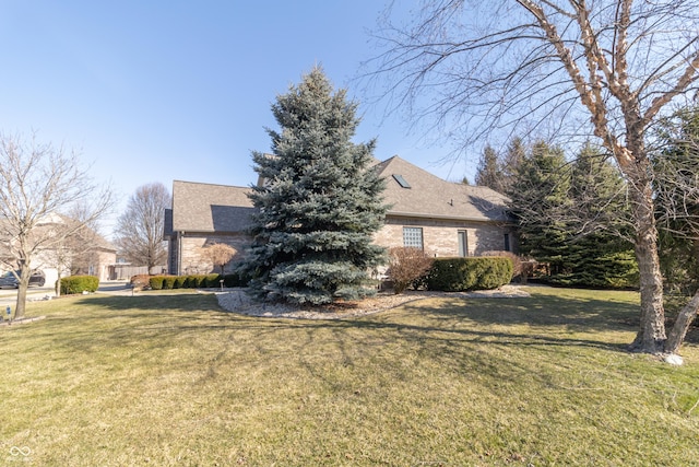 view of side of home with a yard and brick siding