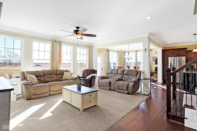 living area featuring ornamental molding, ceiling fan with notable chandelier, recessed lighting, stairway, and dark wood-style flooring