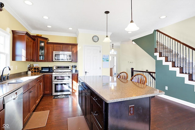 kitchen with dark wood-type flooring, a sink, stainless steel appliances, crown molding, and glass insert cabinets