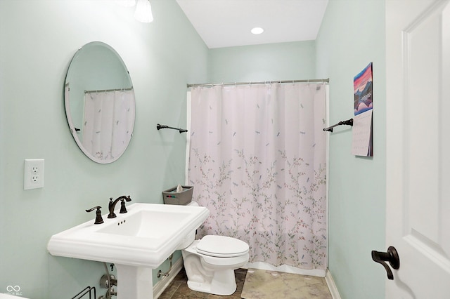 full bathroom featuring curtained shower, toilet, and a sink