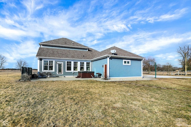 back of house with a patio, a yard, roof with shingles, and a hot tub