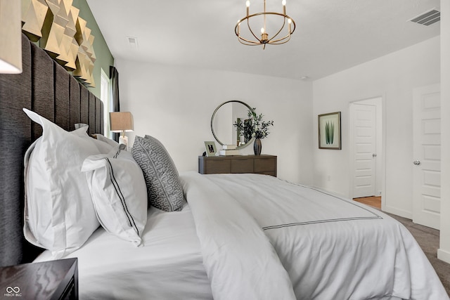 carpeted bedroom featuring visible vents and a notable chandelier