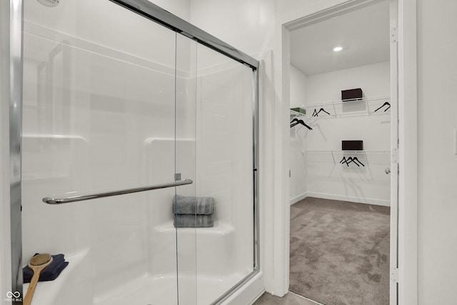 bathroom featuring a walk in closet and a shower stall