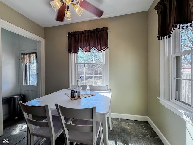 dining room featuring a ceiling fan and baseboards