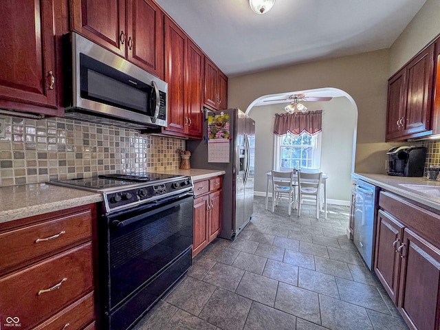 kitchen featuring light countertops, arched walkways, and appliances with stainless steel finishes