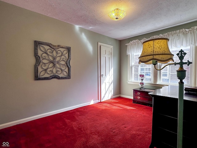 carpeted bedroom with a textured ceiling and baseboards