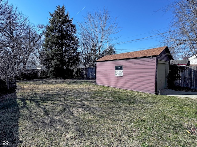 view of yard with an outdoor structure, a fenced backyard, and a garage