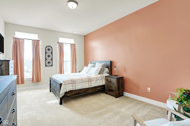 bedroom with baseboards, light carpet, and visible vents