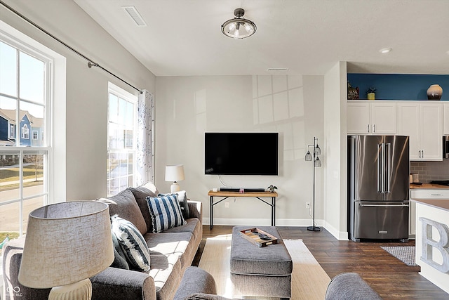 living area featuring dark wood finished floors, visible vents, and baseboards