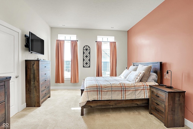 bedroom featuring light carpet, visible vents, and baseboards