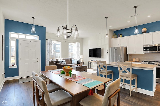 dining area featuring visible vents, baseboards, a notable chandelier, and dark wood-style floors