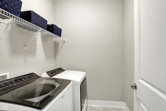 laundry area with laundry area, marble finish floor, baseboards, and separate washer and dryer