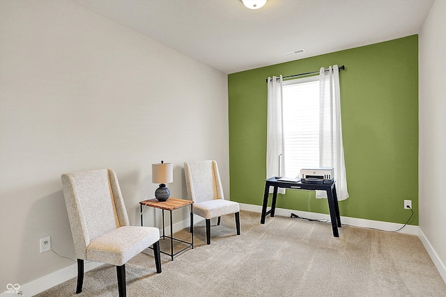 living area with visible vents, baseboards, and carpet flooring