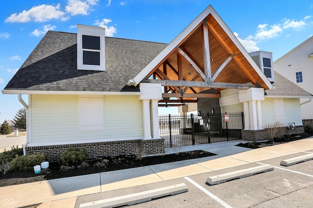 exterior space with uncovered parking, fence, and a shingled roof