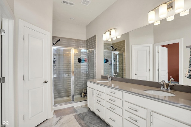 bathroom featuring visible vents, marble finish floor, a shower stall, and a sink