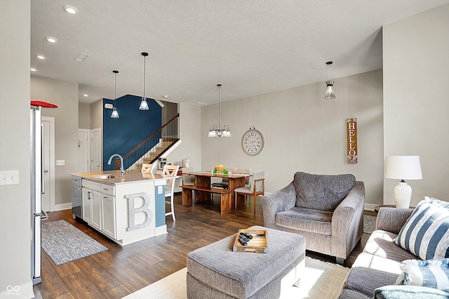 living room with dark wood finished floors, recessed lighting, stairway, baseboards, and a chandelier