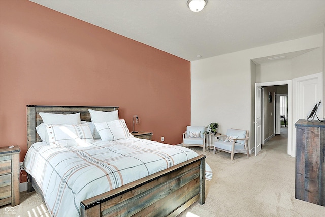 bedroom with light colored carpet and baseboards