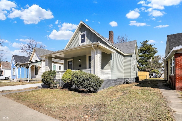 bungalow with a front lawn and a chimney