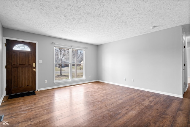 entrance foyer featuring visible vents, a textured ceiling, baseboards, and wood finished floors