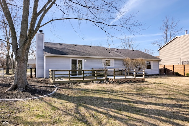 rear view of house featuring a yard, a deck, and fence