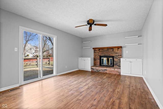 unfurnished living room with visible vents, baseboards, wood finished floors, and a ceiling fan