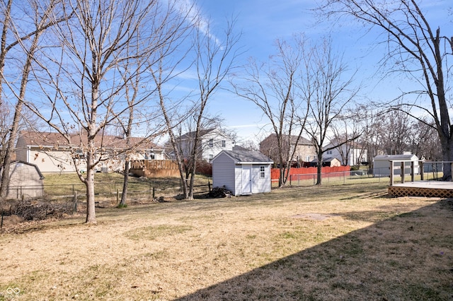 view of yard featuring a storage shed, fence, and an outdoor structure