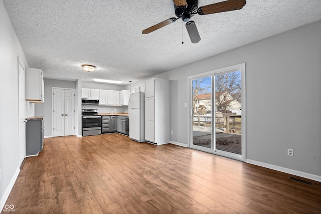 kitchen featuring visible vents, dark wood-type flooring, appliances with stainless steel finishes, baseboards, and ceiling fan