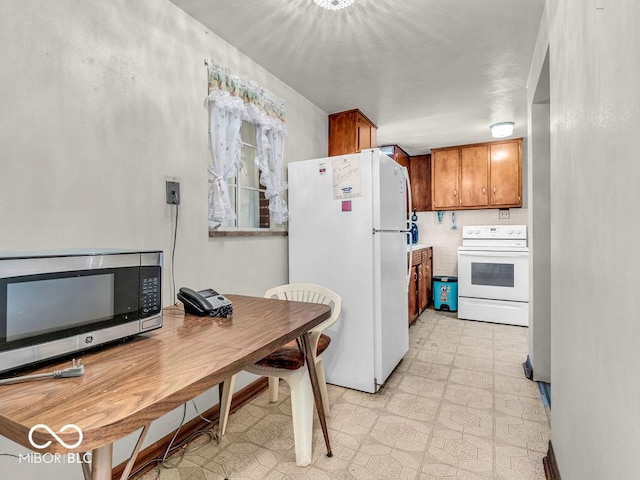 kitchen featuring white appliances, light floors, and brown cabinetry