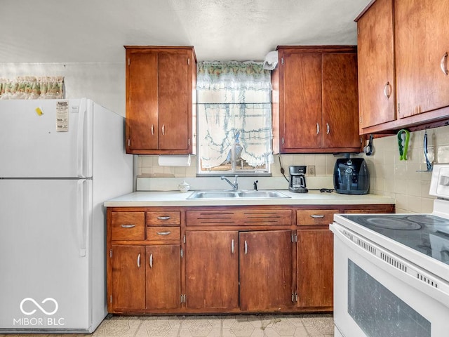 kitchen featuring brown cabinets, a sink, backsplash, white appliances, and light countertops