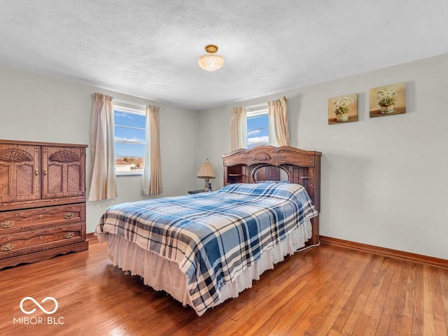 bedroom with baseboards and hardwood / wood-style floors