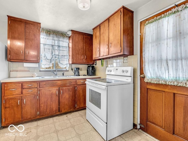 kitchen with light countertops, brown cabinetry, light floors, and white range with electric cooktop