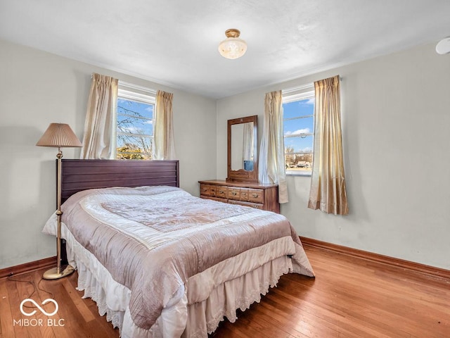 bedroom with baseboards and hardwood / wood-style flooring