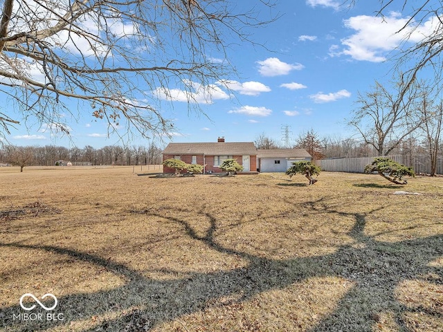 ranch-style home with a front yard, fence, and a chimney