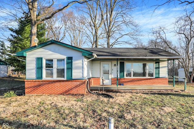 bungalow-style home featuring brick siding, covered porch, and a front lawn