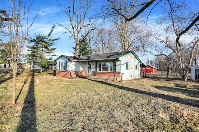 back of property with a porch, a yard, and brick siding