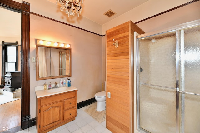 full bath with baseboards, a shower stall, vanity, and toilet