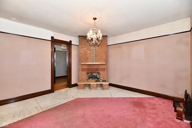 unfurnished living room featuring a notable chandelier, marble finish floor, a barn door, carpet floors, and baseboards