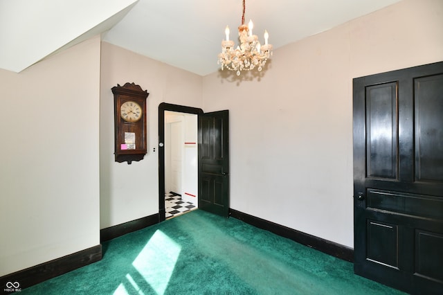 spare room with baseboards, a chandelier, and dark carpet