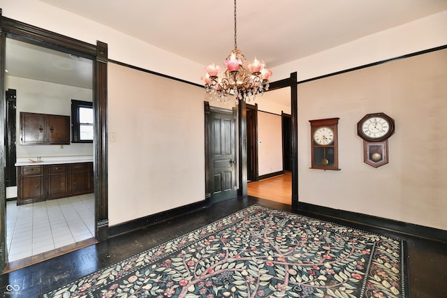 unfurnished room with a barn door, baseboards, and a chandelier