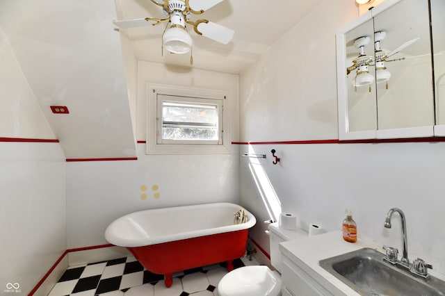 bathroom featuring tile patterned floors, toilet, a ceiling fan, baseboards, and a freestanding bath