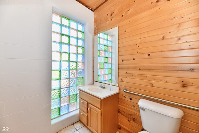 bathroom with tile patterned floors, plenty of natural light, toilet, and vanity