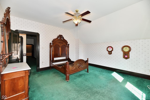 unfurnished bedroom featuring wallpapered walls, baseboards, lofted ceiling, a ceiling fan, and dark colored carpet