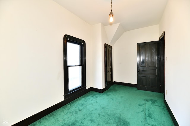 unfurnished room featuring baseboards and dark colored carpet