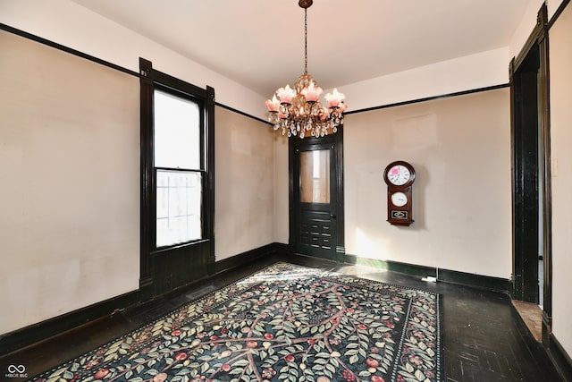 interior space with baseboards and a chandelier